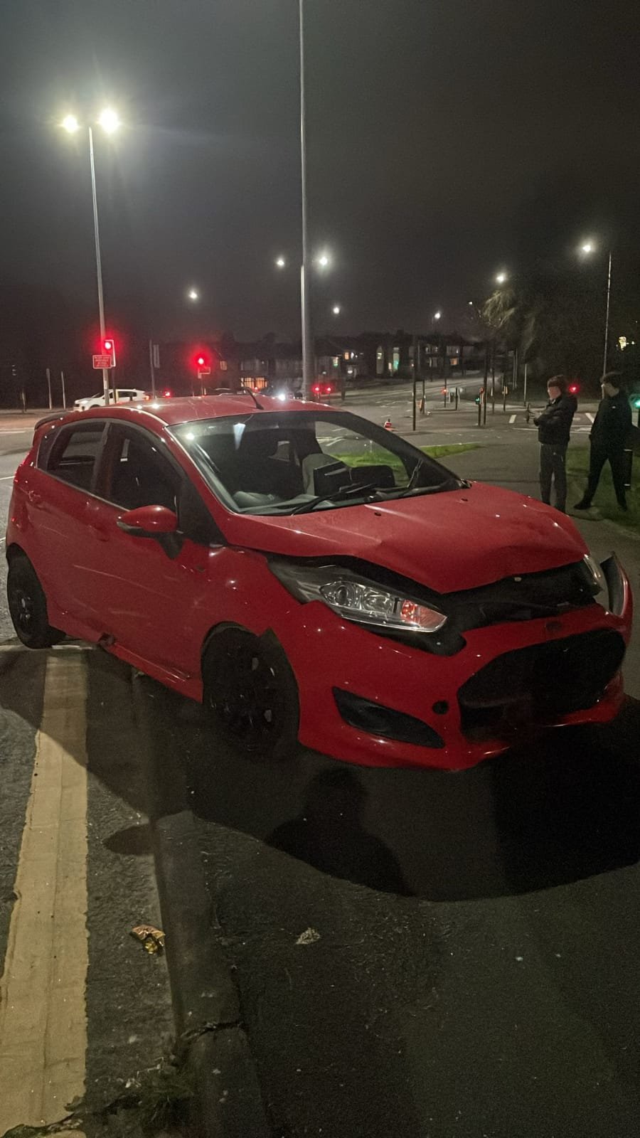 Accident damaged vehicle on the roadside awaiting recovery.