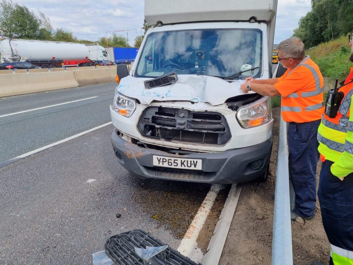 Accident recovery on the motorway — Breakdown Man attending a damaged Ford Transit van.