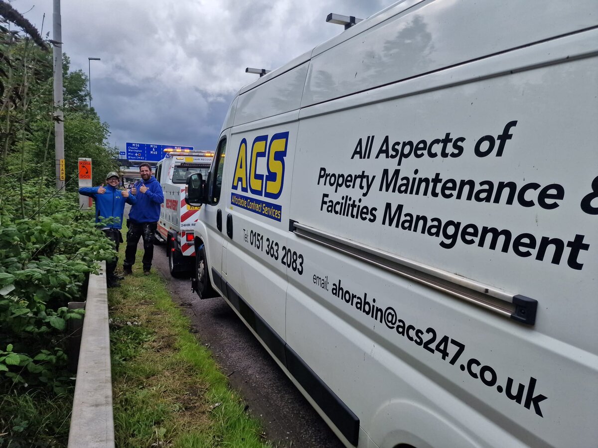 ACS Property Maintenance and Facilities Management courier van being recovered roadside by a Breakdown Man flatbed with the operator and customer stood beside it.