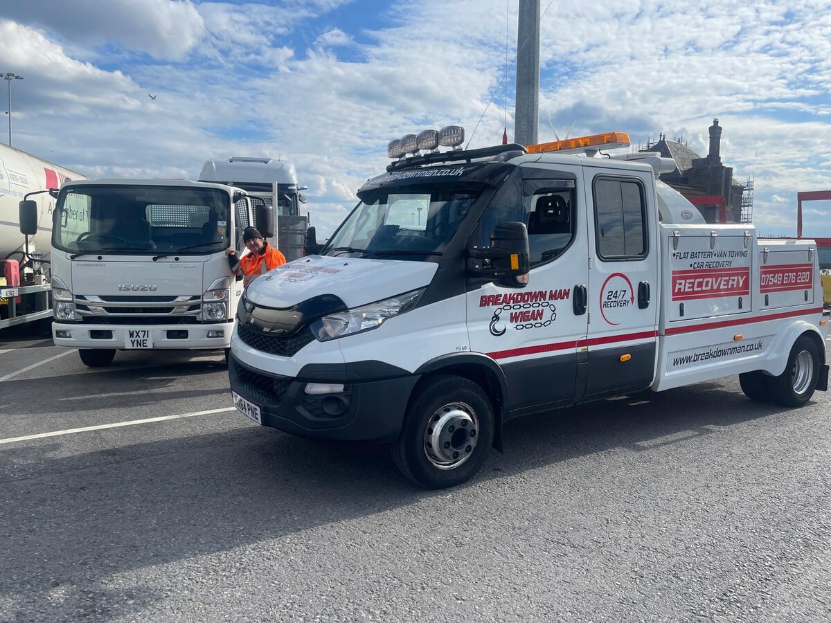 Breakdown Man's branded white Iveco recovery truck and a second cab parked at the Wigan depot.
