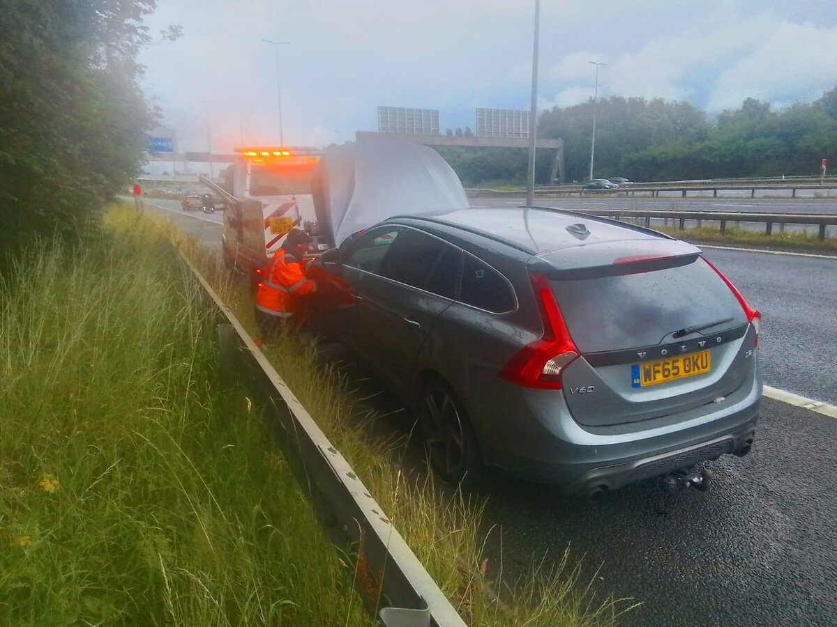 Silver Volvo V60 estate WF65 OKU loaded onto Breakdown Man's flatbed on a misty motorway hard shoulder.