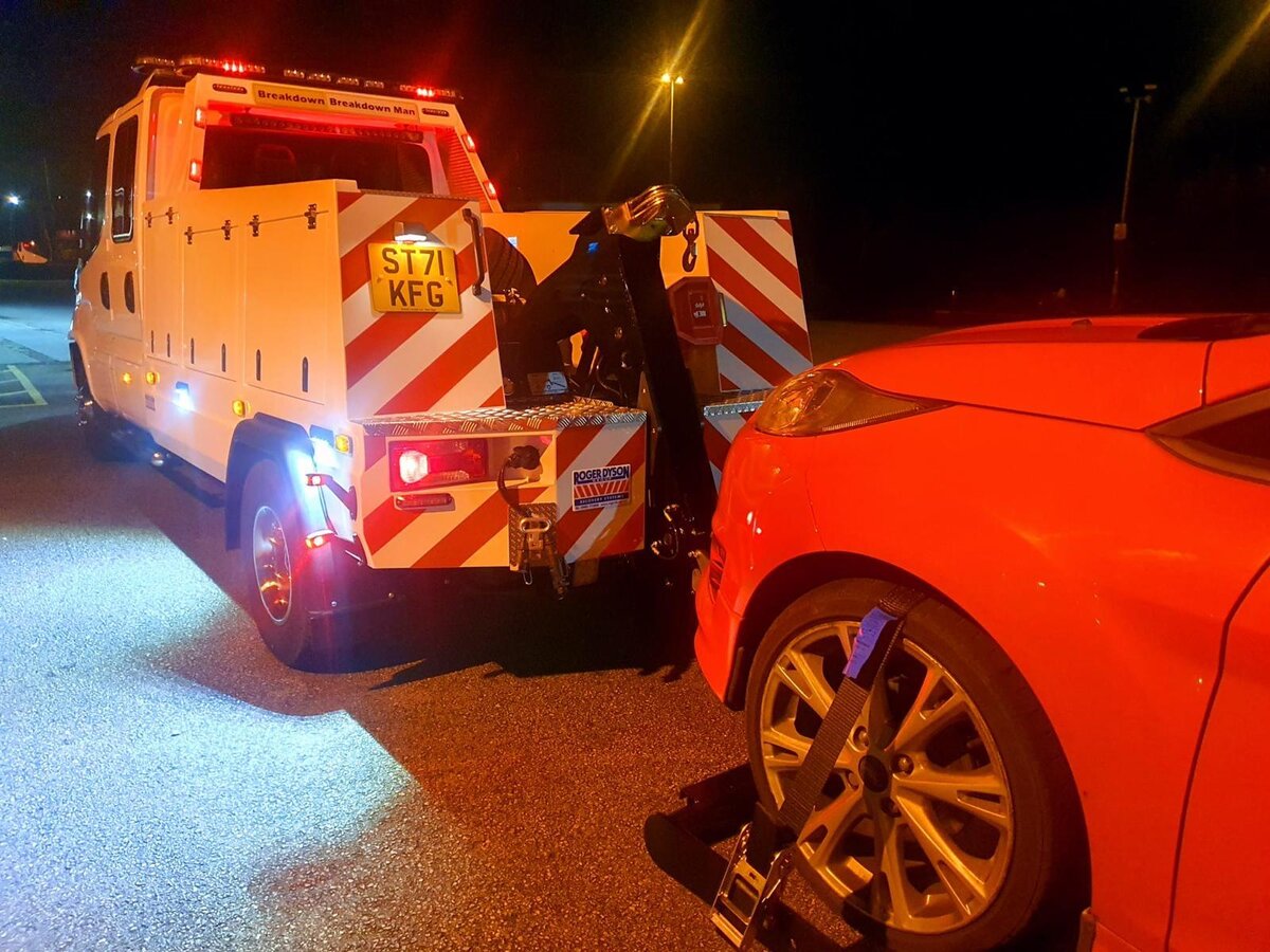 Night-time winching of a red sports car onto Breakdown Man's flatbed.