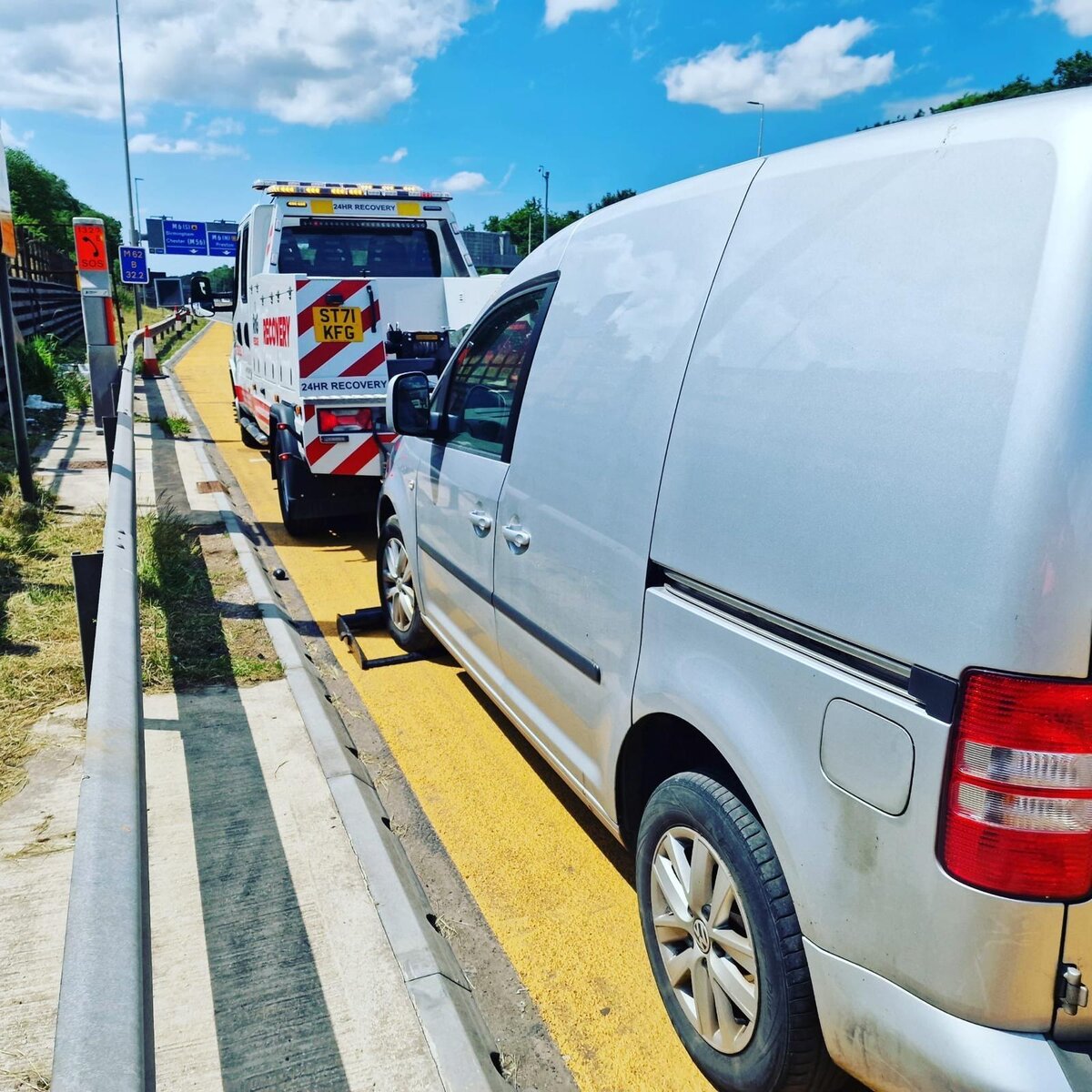 Silver Volkswagen Caddy van loaded behind Breakdown Man's flatbed (ST71 KFG) on the motorway.